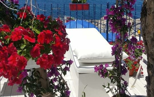 Umbrella and deck chair around outdoor swimming pool in hotel resort